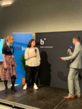 Adrian Feuerbacher diskutiert mit Melanie Stein und Aya Ibrahim auf der Bühne.