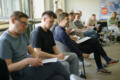 A group of individuals sit in chairs in a room during a learning event