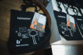 Eine Tasche mit dem Wort "Faktenfan" drauf, sowie ein Büchlein, beide mit dem logo des Bonn Institutes