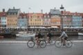 Drei Fahrradfahrer fahren am Nyhavn in Kopenhagen entlang