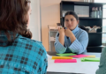 Zwei junge Frauen diskutieren ernsthaft miteinander. Auf dem Tisch liegen Post-it Zettel