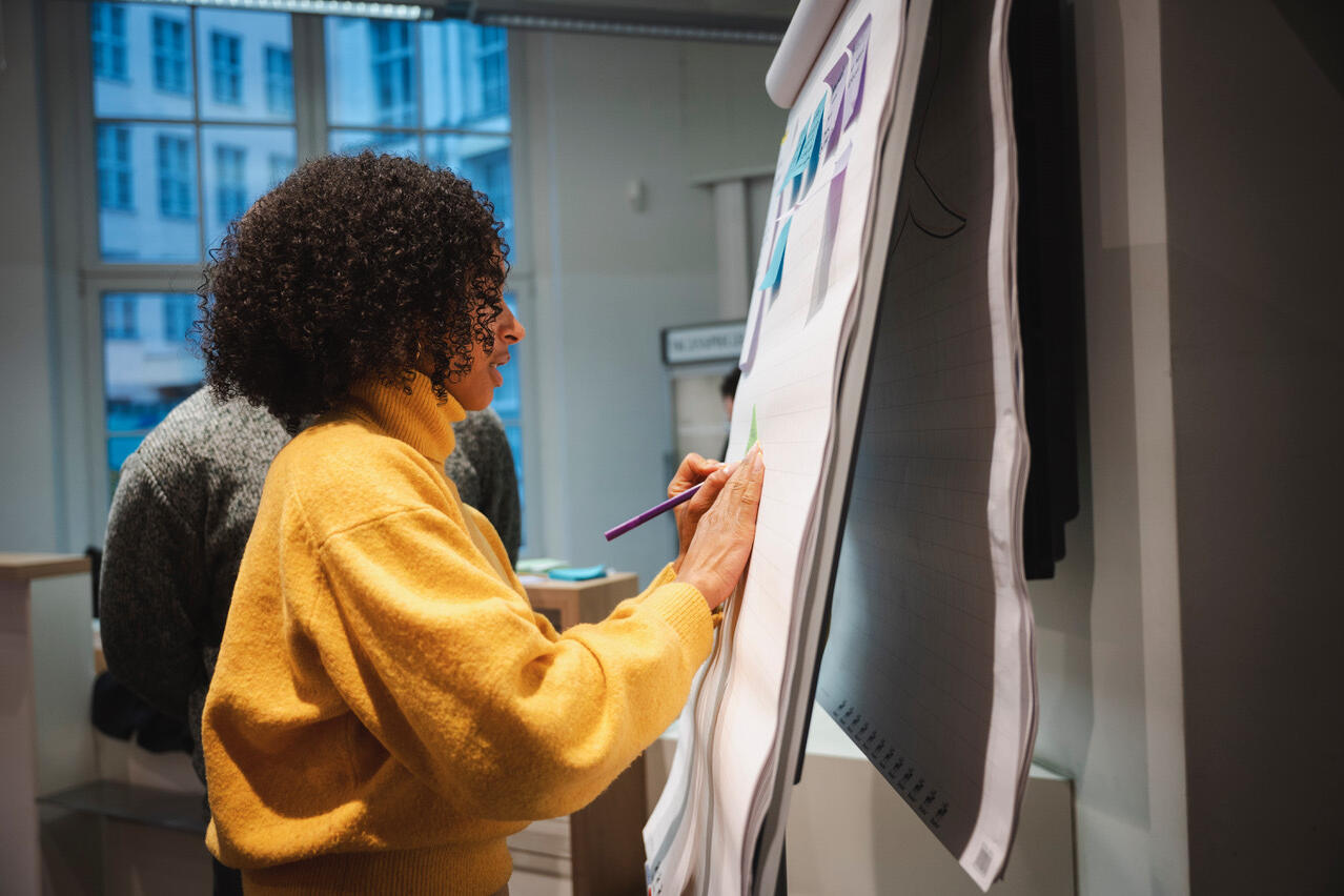 Eine Frau schreibt auf einem Flipchart