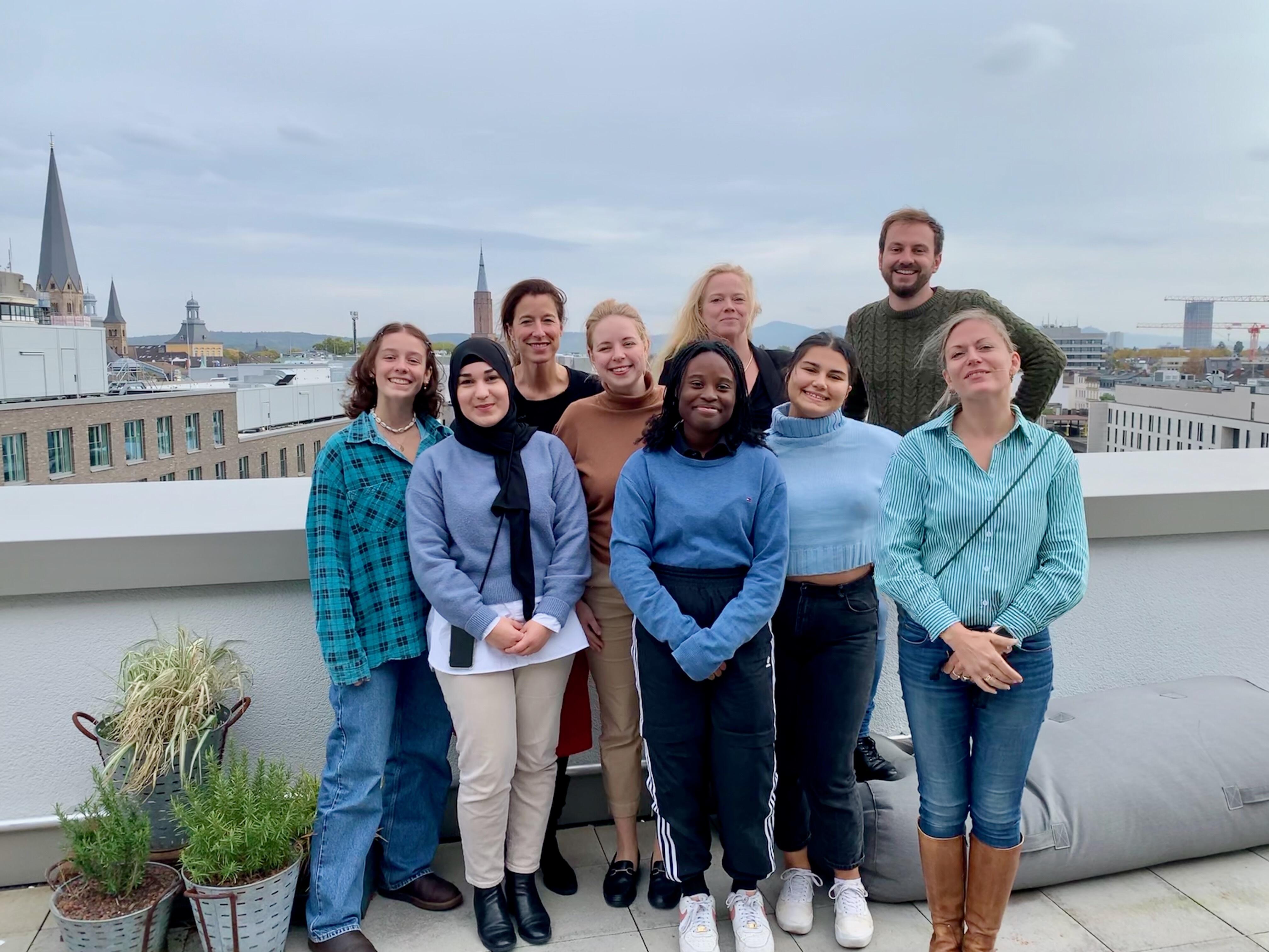 Eine Gruppe von Menschen steht auf dem Dach des Bonn Institute