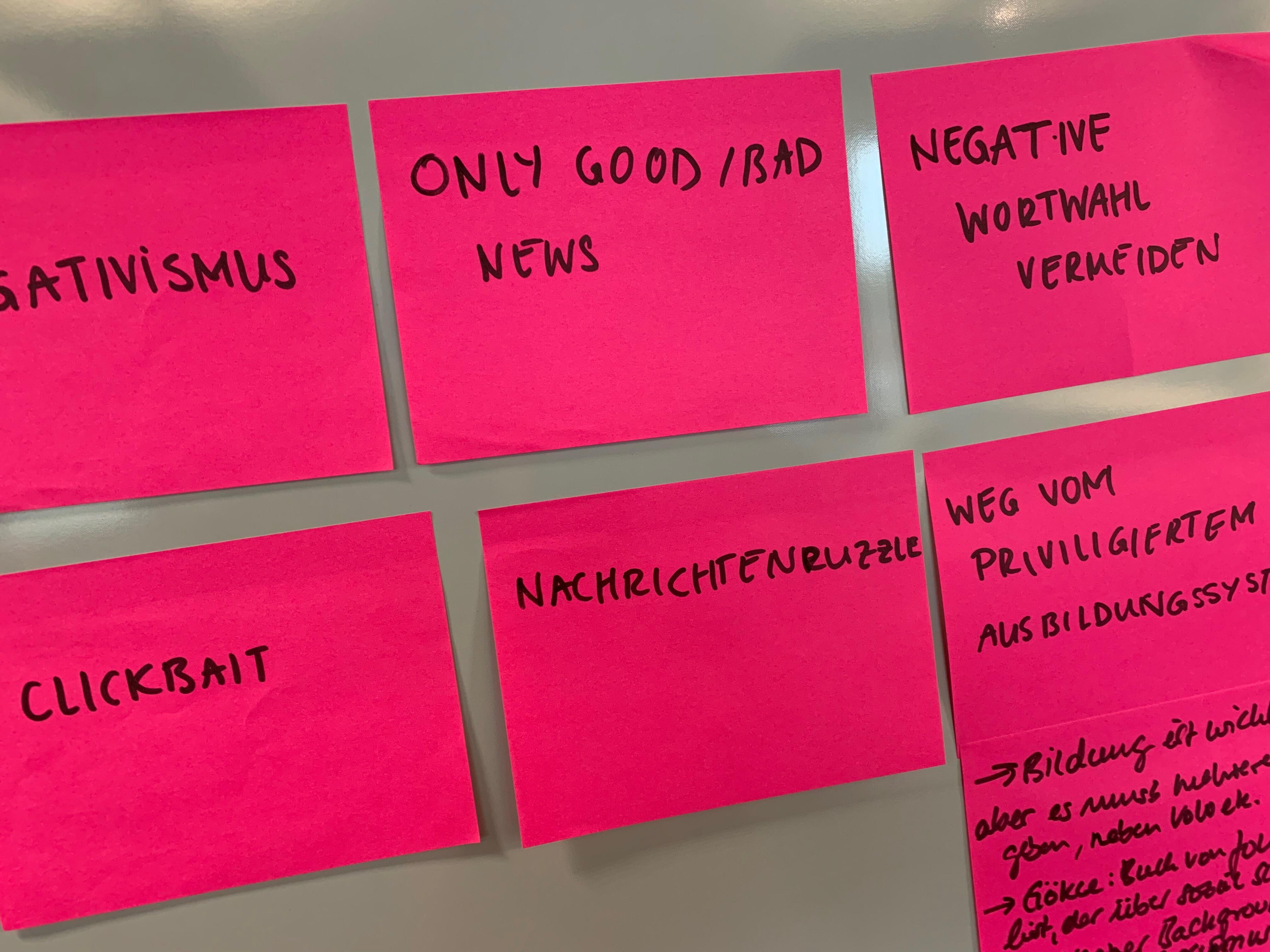 Eine Wand mit mehreren pinken Post-It Zetteln auf denen steht: Only bad news are good news,  negative Wortwahl verwenden, Clickbait, Negative Wortwahl vermeiden, weg vom privilegierten Ausbildungssystem