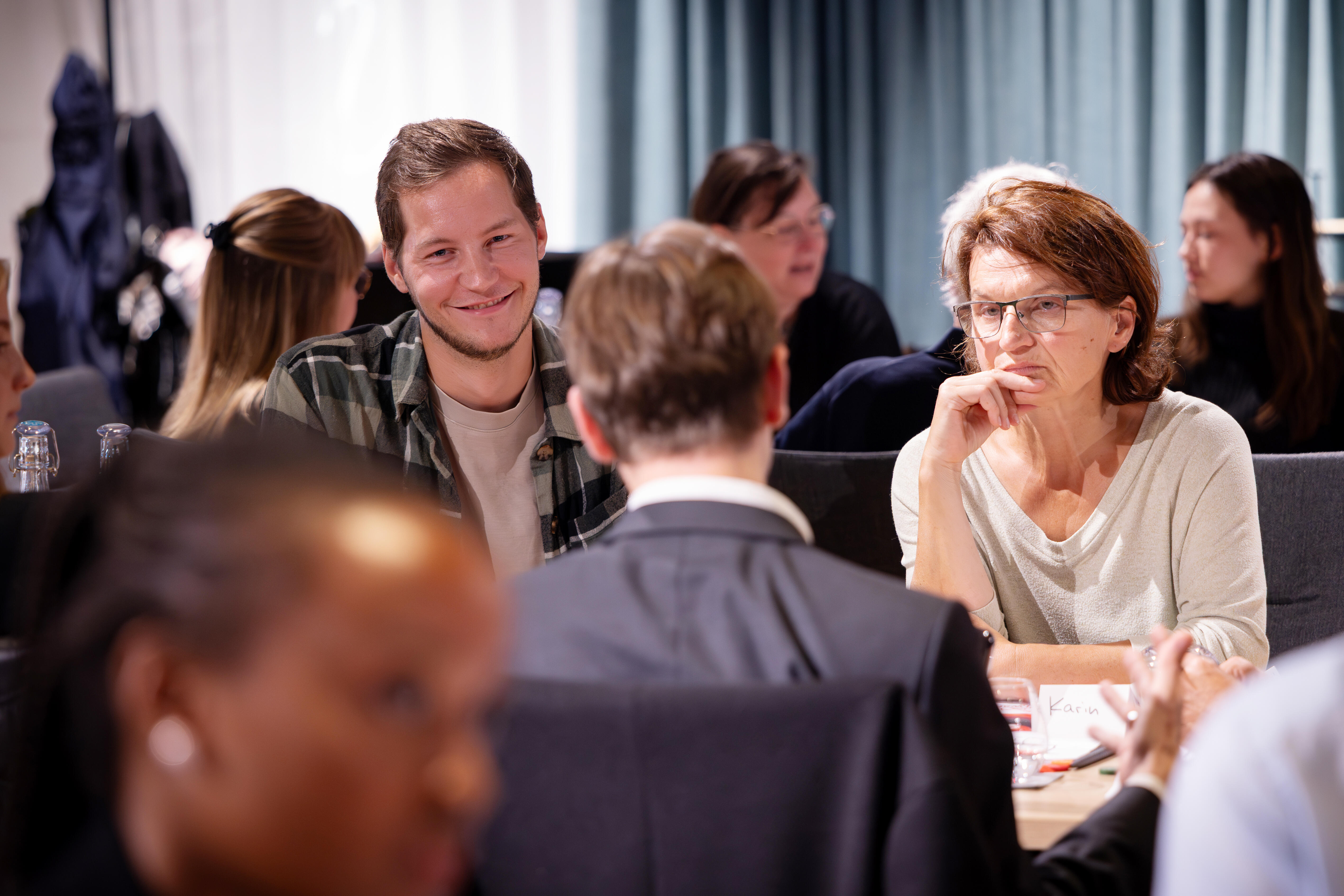 Menschen unterhalten sich an einem Tisch.