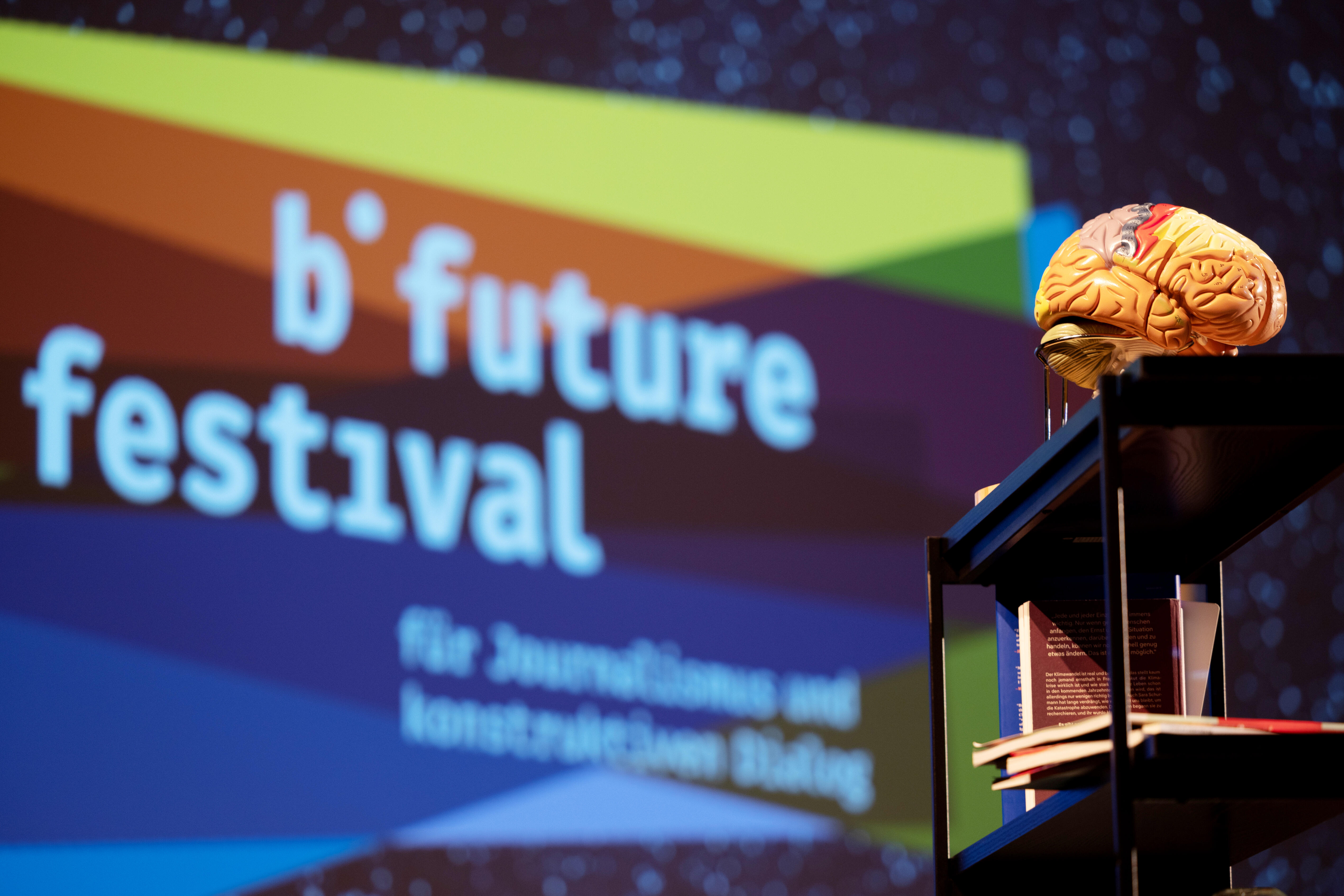 Im Hintergrund das bunte b° future Logo. Im Vordergrund Details von der Hauptbühne.